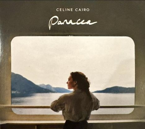 "Celine Cairo, Panacea." Eine Frau betrachtet von einem Balkon aus ruhig eine malerische See- und Berglandschaft.