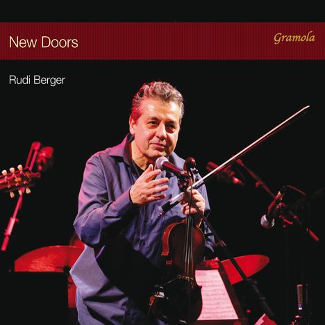 „New Doors“ und „Rudi Berger“ stehen oben links, ein Mann mit Geige spricht ins Mikrofon.