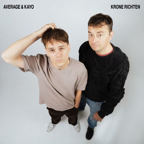 "AVERAGE & KAYO" und "KRONE RICHTEN" steht oben. Zwei Männer schauen nach oben, einer fasst sich an den Kopf.
