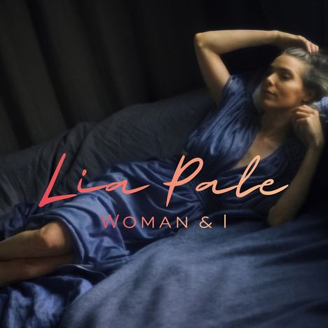 Text: "Lia Pale, WOMAN & I". Eine Frau liegt entspannt, blickt nachdenklich, trägt ein blaues Oberteil.