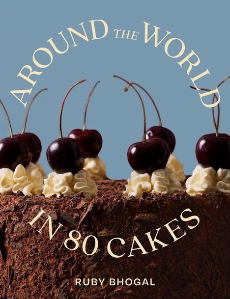 „AROUND THE WORLD IN 80 CAKES“ und darunter „RUBY BHOGAL“. Dunkle Kirschen und Sahne auf einer mit Schokolade bedeckten Torte.