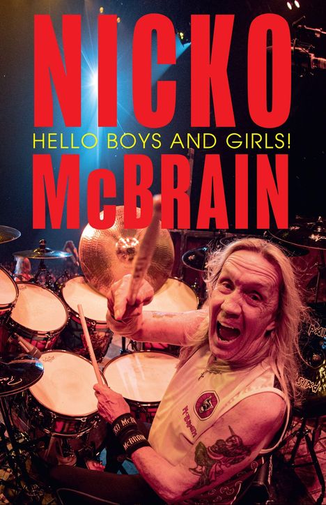 Text: "NICKO McBRAIN HELLO BOYS AND GIRLS!" Ein Mann spielt leidenschaftlich Schlagzeug auf der Bühne.