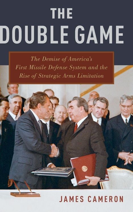 „The Double Game“ oben, unten „James Cameron“. Zwei Männer geben sich die Hand, umgeben von anderen Männern.