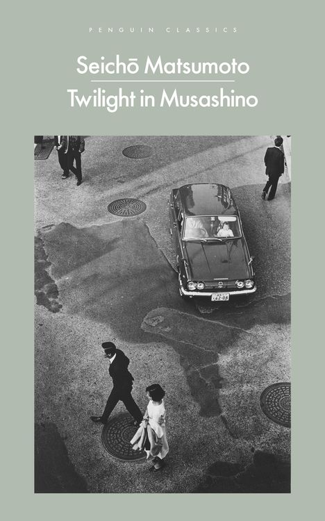 Oben der Text: "Seichō Matsumoto, Twilight in Musashino". Schwarzweißfoto einer Straße mit Auto und Passanten aus der Vogelperspektive.