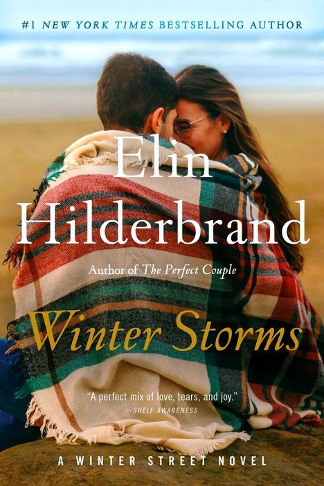Text: „Elin Hilderbrand, Winter Storms, #1 New York Times Bestselling Author“. Ein Paar in eine Decke gehüllt am Strand.