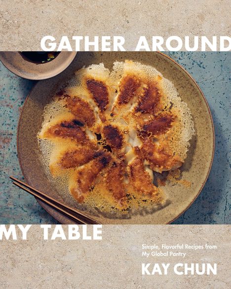 „GATHER AROUND MY TABLE“. Ein Teller mit goldbraun gebratenen Teigtaschen und Essstäbchen daneben.