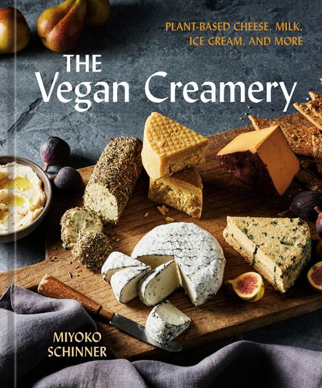 "The Vegan Creamery" von Miyoko Schinner. Verschiedene vegane Käse, Feigen und ein Messer auf einem Holzbrett.