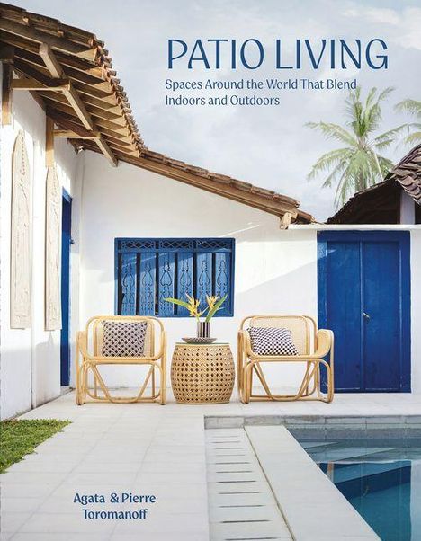 „PATIO LIVING - Spaces Around the World That Blend Indoors and Outdoors“. Zwei Sessel, Tisch, blaues Fenster, Palme.
