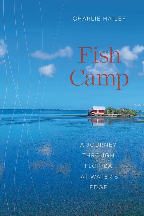 "Charlie Hailey Fish Camp. A journey through Florida at water’s edge." Ein rotes Haus steht am Wasser unter blauem Himmel.