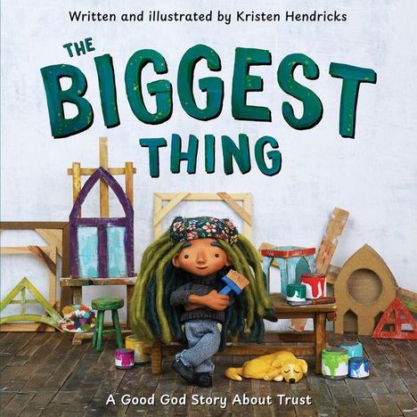 "The Biggest Thing" und "A Good God Story About Trust" auf dem Cover eines Buches mit bunter Holzwerkstatt und Puppe.