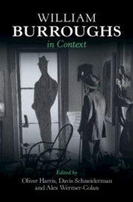 "William Burroughs in Context" steht oben. Ein Mann mit Hut und Anzug reflektiert sich im Fenster, neben ihm ein Stuhl.