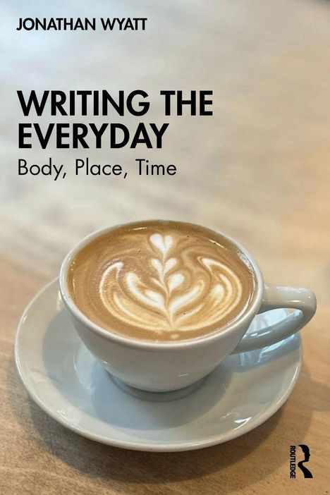 "WRITING THE EVERYDAY: Body, Place, Time" von Jonathan Wyatt. Eine Tasse Kaffee mit Latte Art in einem Café.