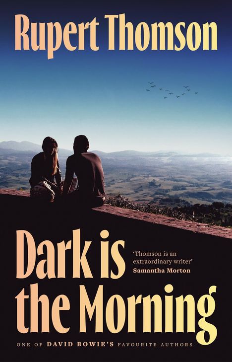 Buchtitel: "Dark is the Morning" von Rupert Thomson. Zwei Personen sitzen auf einer Mauer mit Blick auf eine weite Landschaft.