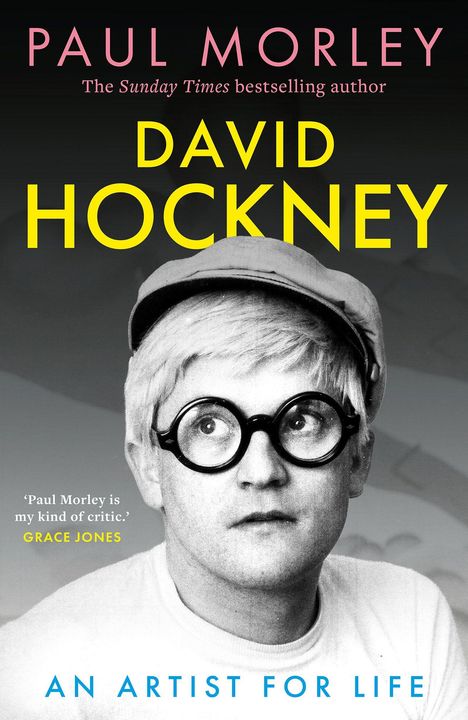 „PAUL MORLEY“, „DAVID HOCKNEY“, „AN ARTIST FOR LIFE“. Ein Mann mit Brille, Mütze, schaut leicht nach oben.