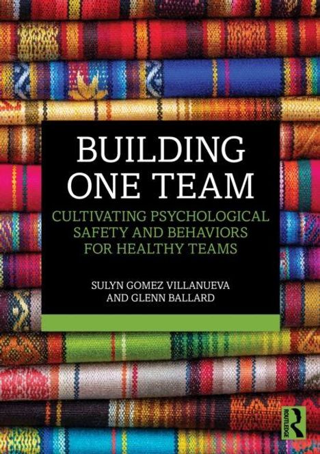 "BUILDING ONE TEAM" in weißer Schrift auf schwarzem Hintergrund, bunte gewebte Textilien im Hintergrund.