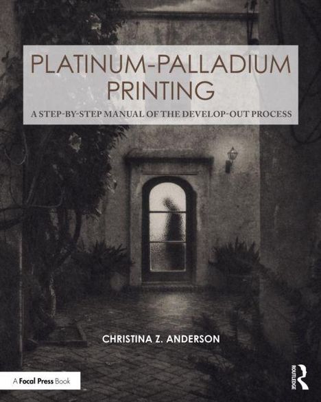 "PLATINUM-PALLADIUM PRINTING" über einem Torbogen. Eine Silhouette steht hinter einer Glastür, umgeben von Pflanzen.