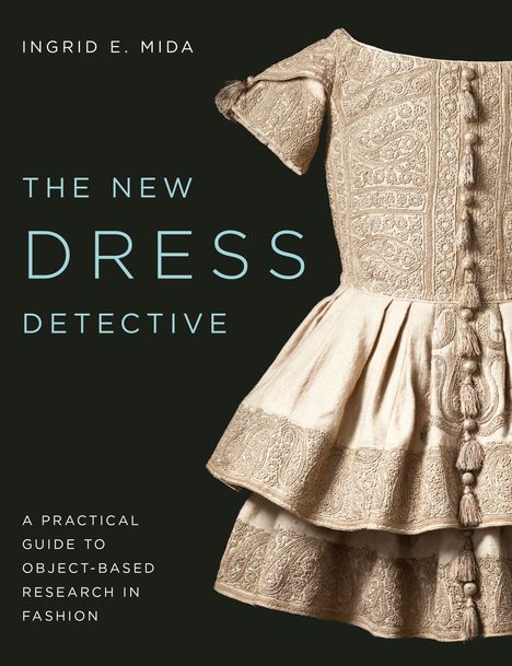 INHALT: Titel "The New Dress Detective", Autor "Ingrid E. Mida". Beschreibt ein reich verziertes, cremefarbenes Kleid.