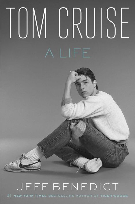 "Tom Cruise: A Life" von Jeff Benedict. Schwarz-Weiß-Foto eines sitzenden Mannes in Jeans und Sneakers.