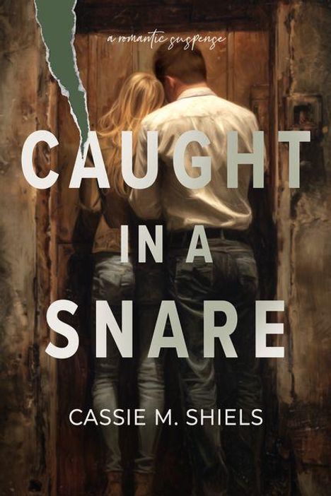 „A Romantic Suspense“, „Caught in a Snare“, „Cassie M. Shiels“. Zwei Personen stehen eng beieinander vor einer Tür.