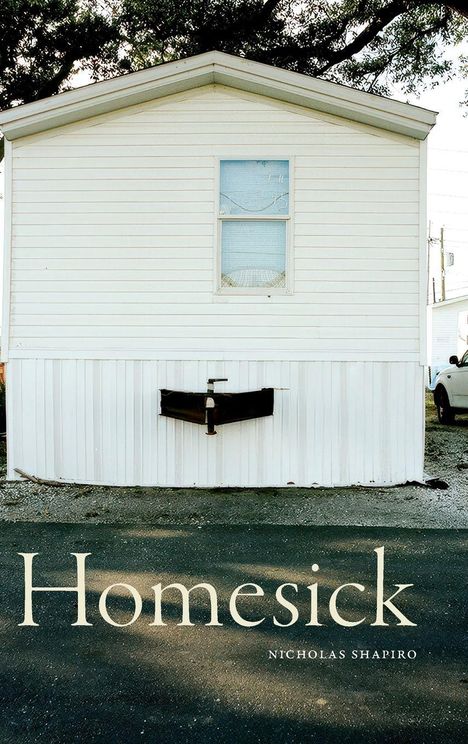 „Homesick“ und „Nicholas Shapiro“ stehen unten. Ein weißes Mobilheim mit kleinem Fenster und Baum im Hintergrund.