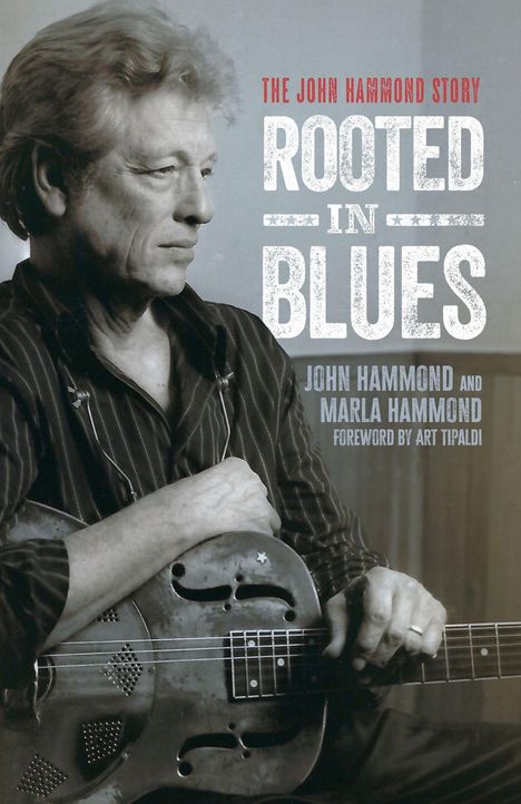 Text: "THE JOHN HAMMOND STORY ROOTED IN BLUES JOHN HAMMOND AND MARLA HAMMOND FOREWORD BY ART TIPALDI".  
Ein Mann hält eine Gitarre.