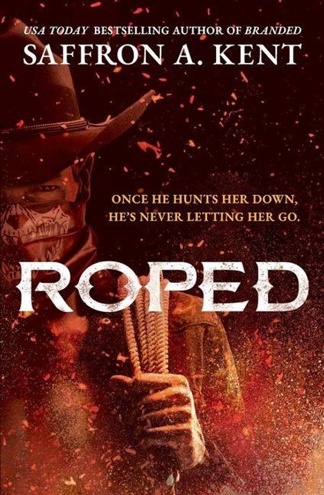 „SAFFRON A. KENT“, „ONCE HE HUNTS HER DOWN, HE'S NEVER LETTING HER GO“, „ROPED“. Dunkle Cowboy-Figur mit Hut und Seil.