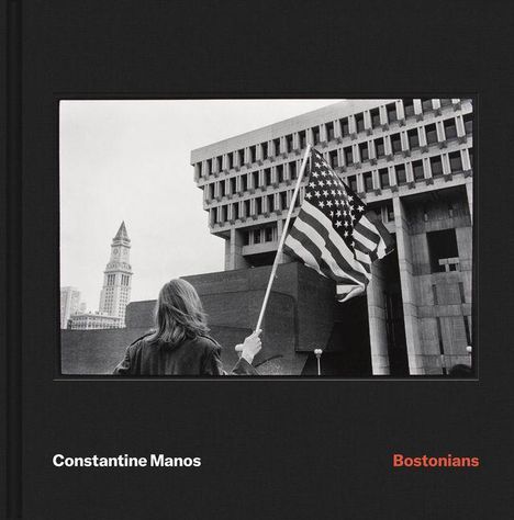 Constantine Manos, Bostonians. Eine Person mit amerikanischer Flagge vor einem markanten Gebäude in einer Stadt.