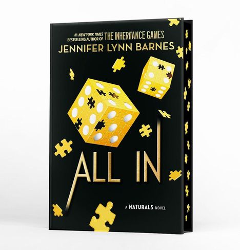 Text: "The Inheritance Games", "Jennifer Lynn Barnes", "ALL IN", "A Naturals Novel". Goldene Würfel und Puzzleteile.