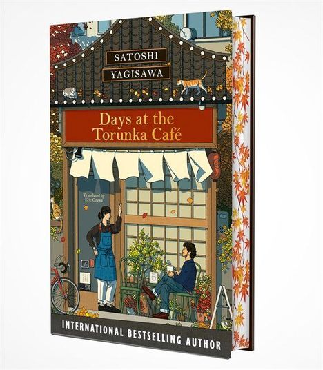 "Buch: 'Days at the Torunka Café' von Satoshi Yagisawa. Illustration eines Cafés mit zwei Menschen und herbstlichem Dekor."