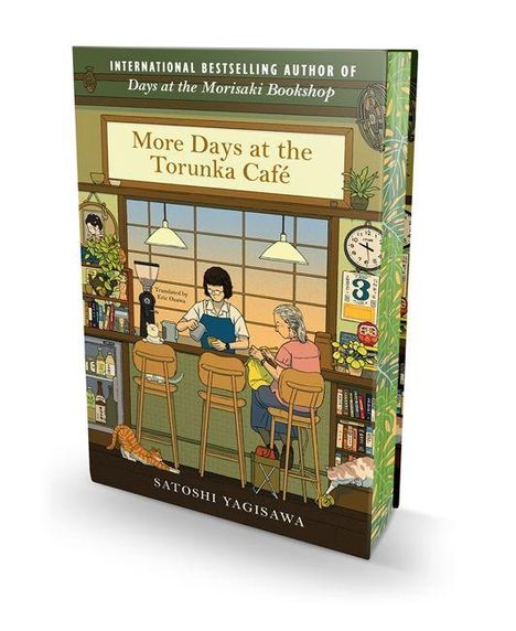 Buchumschlag: "More Days at the Torunka Café" von Satoshi Yagisawa. Zwei Personen sitzen in einem Café, Retro-Dekor, Katzen.