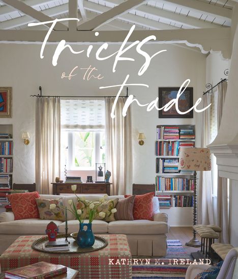 „Tricks of the Trade“ und „Kathryn M. Ireland“; Wohnzimmer mit einem Sofa, Bücherregalen und hellem Ambiente.