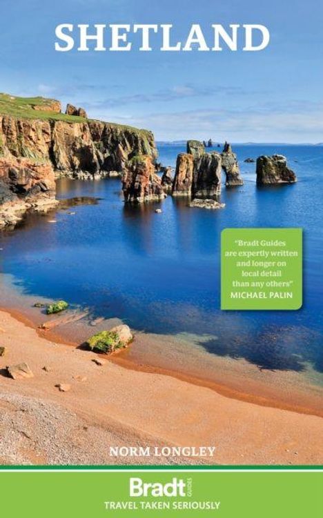 "Shetland", Zitat von Michael Palin über Bradt Guides. Küstenlandschaft mit Felsen und blauem Meer bei klarem Himmel.