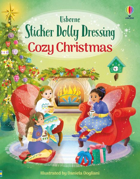 "Usborne Sticker Dolly Dressing Cozy Christmas." Drei Mädchen sitzen vor einem Kamin, umgeben von Geschenken und einem Weihnachtsbaum.