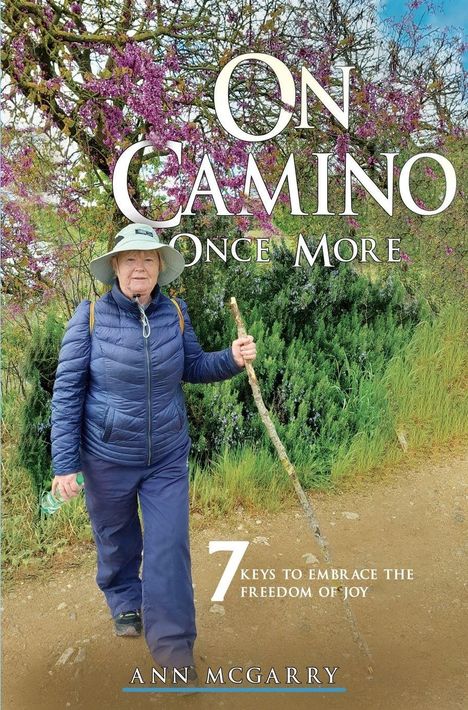 "ON CAMINO ONCE MORE. 7 KEYS TO EMBRACE THE FREEDOM OF JOY. ANN MCGARRY." Eine Frau wandert mit Stock.