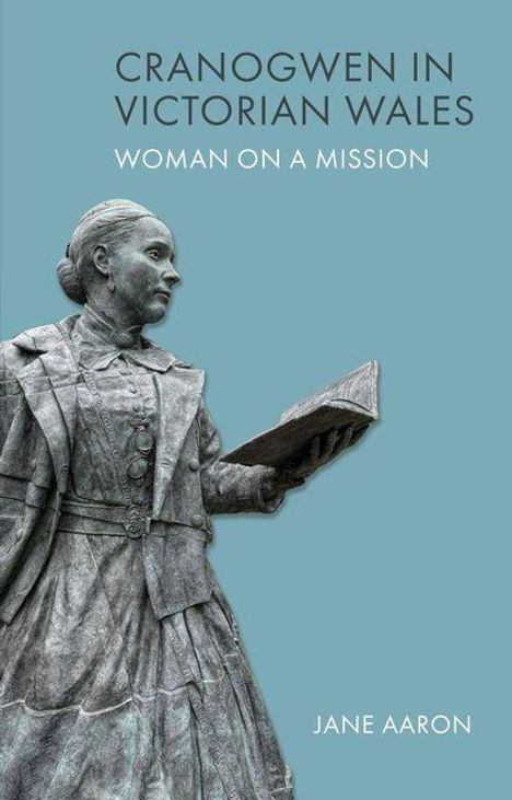 CRANOGWEN IN VICTORIAN WALES, WOMAN ON A MISSION, JANE AARON. Statue einer Frau mit Buch auf hellem Hintergrund.