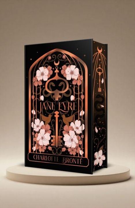 „JANE EYRE“ und „CHARLOTTE BRONTE“ stehen in eleganter Schrift auf einem verzierten Buchcover mit Blumen und Vögeln.