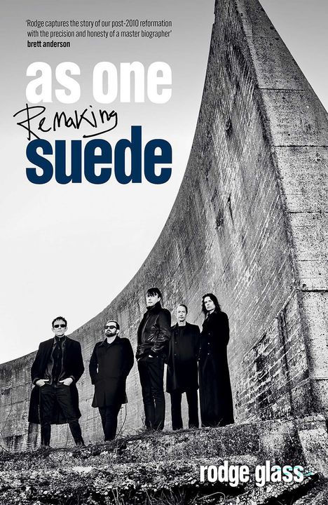 Text: "as one Remaking suede rodge glass." Eine Gruppe von fünf Männern steht vor einer großen Betonwand.