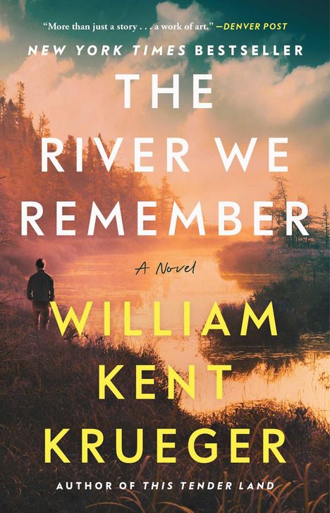 Text: "New York Times Bestseller. The River We Remember. A Novel. William Kent Krueger. Author of This Tender Land."  
Eine Person steht vor einem ruhigen Fluss bei Sonnenuntergang.