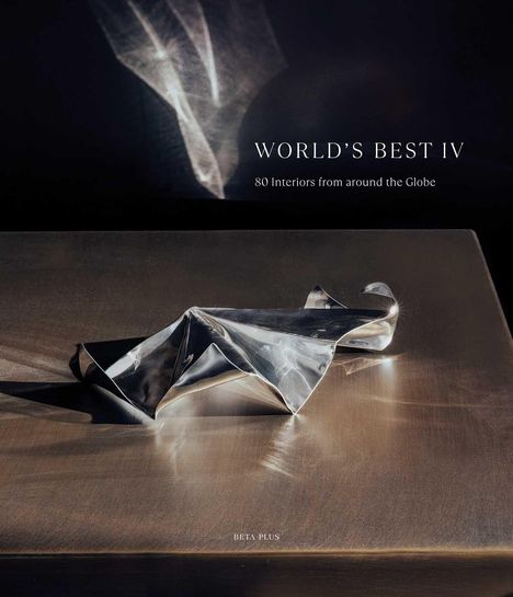 "WORLD'S BEST IV: 80 Interiors from around the Globe." Eine glänzende, zerknitterte Metallskulptur auf einem Tisch.