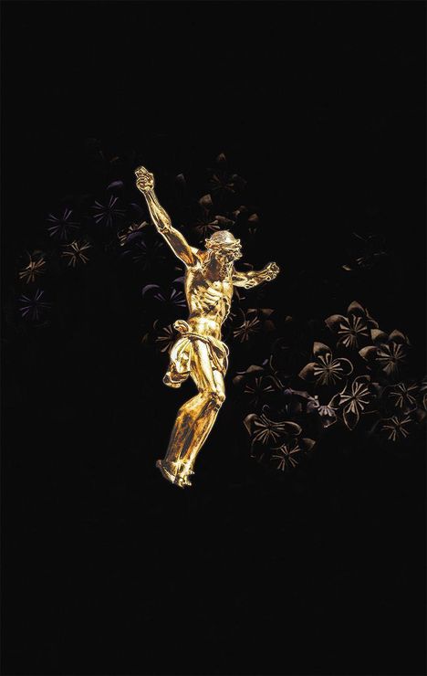 Keine Texte vorhanden. Eine goldene Christusfigur schwebt vor einem dunklen Hintergrund mit floralen Mustern.