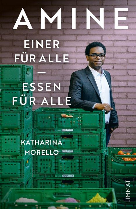 „Amine. Einer für alle – Essen für alle.“ Ein Mann steht vor grünen Kisten aus Kunststoff.