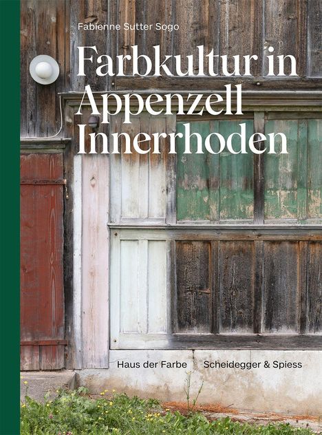 "Farbenfroh verwitterte Holzvertäfelungen mit eingelassener Lampe, umgeben von grünem Gras und Pflanzen."