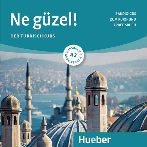 "Ne güzel! Der Türkischkurs" und "Hueber" Text auf Dachlandschaft mit Moscheen und einem Wasserweg im Hintergrund.