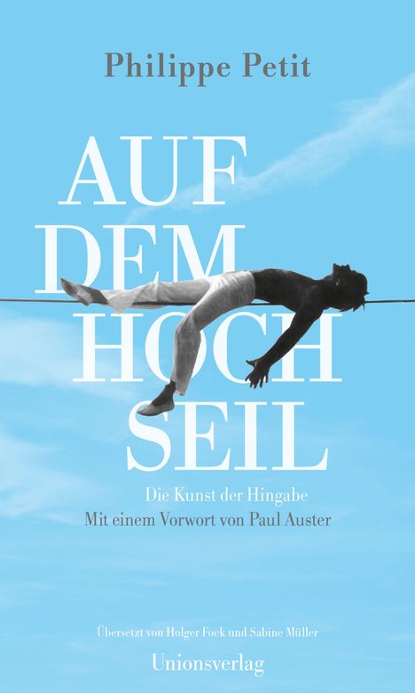 „Philippe Petit: AUF DEM HOCHSEIL. Die Kunst der Hingabe. Mit Vorwort von Paul Auster.“ 
Eine Person liegt auf einem Seil.