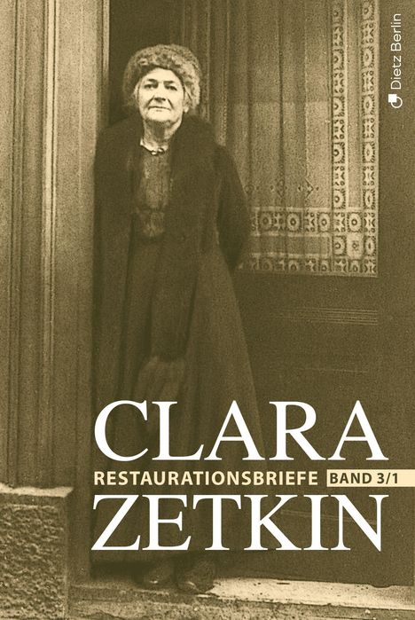„Clara Zetkin, Restaurationsbriefe Band 3/1“. Eine ältere Frau in einem eleganten Mantel vor einer verzierten Tür.