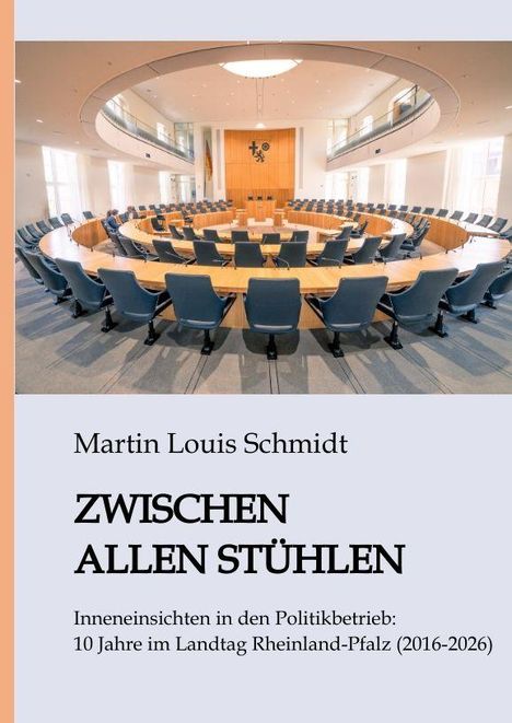 Text: "Martin Louis Schmidt - ZWISCHEN ALLEN STÜHLEN - Inneneinsichten in den Politikbetrieb: 10 Jahre im Landtag Rheinland-Pfalz (2016-2026)." Im Hintergrund des Covers ein leerer, ovaler Sitzungssaal.