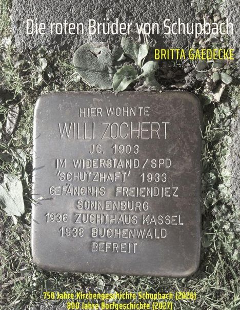 Text: "Die roten Brüder von Schupbach, Britta Gaedecke, Hier wohnte Willi Zochert, Jg. 1903, im Widerstand/SPD, Schutzhaft 1933, Gefängnis Freiendiez, Sonnenburg, 1936 Zuchthaus Kassel, 1938 Buchenwald, befreit, 750 Jahre Kirchengeschichte Schupbach (2026), 800 Jahre Dorfgeschichte (2027)." 

Eine Gedenkplatte auf einem Gehweg, umgeben von Pflanzen.