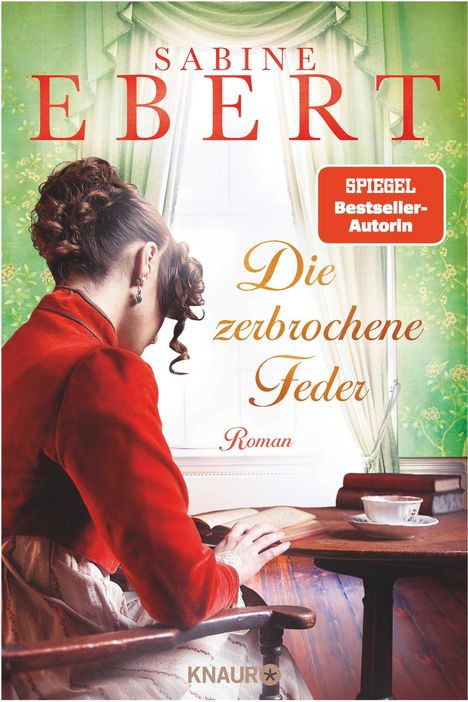 Titel: "Die zerbrochene Feder". Autorin: Sabine Ebert. Hinweis: "SPIEGEL Bestseller-Autorin". Frau in historischer Kleidung sitzt am Tisch.