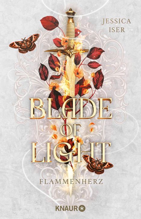 "Blade of Light: Flammenherz" von Jessica Iser. Goldenes Schwert, umgeben von roten Blättern und Flammen, vor detailreichem Muster.