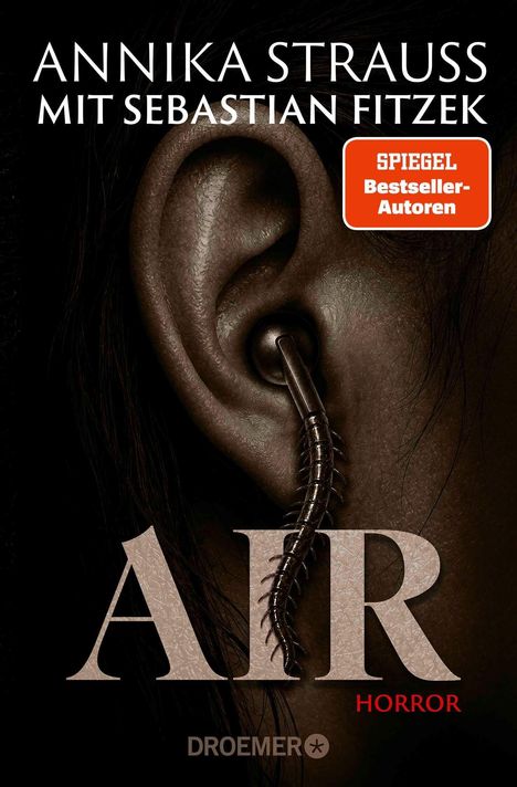 "ANNIKA STRAUSS MIT SEBASTIAN FITZEK", "SPIEGEL Bestseller-Autoren", "AIR", "HORROR", "DROEMER". Ein Ohr, darin ein Ohrring als Tausendfüßler.